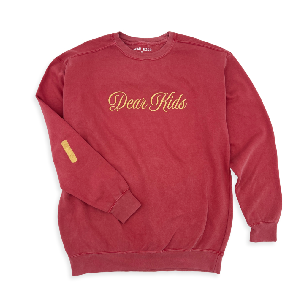 Studio-style shot of the Band-Aid Pullover on a transparent background, showcasing its unique Band-Aid design on the elbow area.