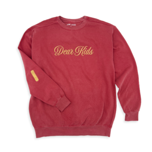 Studio-style shot of the Band-Aid Pullover on a transparent background, showcasing its unique Band-Aid design on the elbow area.